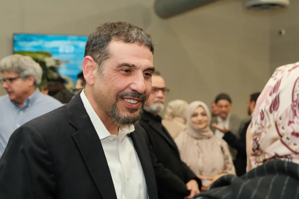 Dr. Adam Hamawy smiling as he greets supporters at a community event