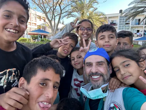 El Dr. Hamawy se toma una selfie con un grupo de niños sonrientes en Gaza