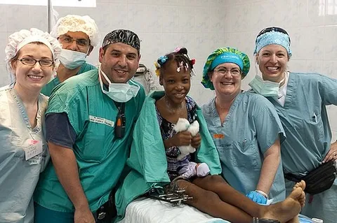 El Dr. Hamawy con un equipo quirúrgico y una pequeña paciente en Haití
