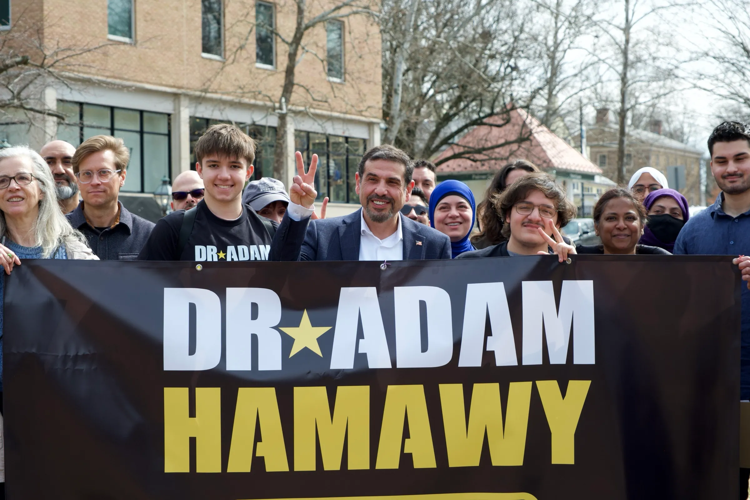 Dr. Adam Hamawy and supporters holding a campaign banner